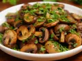 Champignons de Paris sautés, parfaits pour une recette facile et savoureuse. Garnis de persil frais.