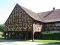Piękny dom podcieniowy z charakterystyczną, zdobioną szachulcową fasadą i ceramicznym dachem.