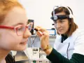 Lekarka bada ucho dziewczynki, która ma okulary. Badanie może pomóc zdiagnozować niedosłuch u dziecka.