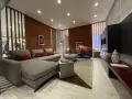 Soggiorno moderno con pareti color terracotta e divano grigio. Effetti pittura pareti moderne che creano un'atmosfera calda e accogliente.