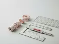 Ruban de couture nervuré et règles de précision, outils essentiels pour des mesures parfaites.
