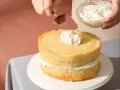 Nakładanie puszystego kremu na biszkoptowe ciasto z mascarpone.