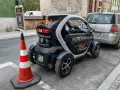 Czarny Renault Twizy z napisem "Free! for our guests" zaparkowany przed hotelem Petite Fleur. Obok znak parkingowy dla gości hotelowych.