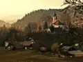 Malownicza wieś z kościołem na wzgórzu, otoczona jesiennym lasem. Marzenie o relaksie w szczawnickich basenach termalnych.