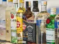 Szereg butelek alkoholi: wódka, rum, whisky, gin. Idealne do shotów warstwowych kontra shoty mieszane.