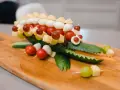Krokodil aus Gurke mit herzhaftem Fingerfood für Kinder: Käse, Tomaten, Mozzarella & Trauben auf Spießen.