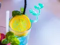 Orzeźwiający drink z sokiem żurawinowym, ozdobiony plasterkiem cytryny i listkami mięty. Idealny na upalne dni.