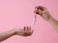 Dwie dłonie, jedna trzyma tampon z aplikatorem, druga wyciągnięta do przyjęcia. Ciasna pochwa to temat, który wymaga dyskrecji.