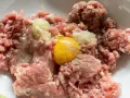 Mielone mięso z dodatkiem cebuli i jednego jajka, gotowe do dalszego przygotowania. Ile jajek do mielonych? Zazwyczaj jedno na pół kilograma mięsa.