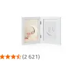 A white diptych frame showing a sleeping baby on a moon and a baby handprint.