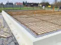 Siatka zbrojenia na fundamencie z białych bloczków styropianowych, gotowa do zalania betonem.