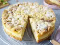 Ein saftiger Rhabarberkuchen mit Puddingfüllung und Streuseln, bestäubt mit Puderzucker.