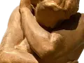 Détail d'une sculpture en bronze, une œuvre d'art d'Auguste Rodin, montrant un torse musclé et un bras levé.