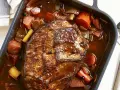 Herzhaftes Rinderbratenstück in dunkler Sauce mit Karotten und Lauch, perfekt für festliche Schmorgerichte an Weihnachten.