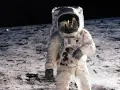 Un astronaute sur la Lune, le 20 juillet 1969. Le reflet dans son casque montre la Terre et d'autres astronautes.