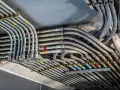Plątanina metalowych i plastikowych rur, czyli peszli, prowadzących instalację elektryczną pod sufitem.