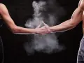 Dwie dłonie, męska i kobieca, spotykają się w chmurze magnezji. Pokazuje to siłę i determinację, cechy, które mogą być obecne u każdego, niezależnie od płci.