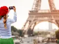 Mujer con boina roja toma foto de la Torre Eiffel. ¡Ideas de qué ver en París!