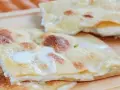 Focaccia di Recco, sottile e dorata, con il suo ripieno filante di formaggio fresco.