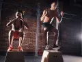 Para ćwicząca CrossFit wykonuje skoki na skrzyni w siłowni.