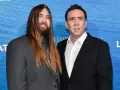 Weston Coppola Cage z długimi włosami i Nicolas Cage na niebieskim tle.