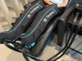 Are leg compression massagers good for you? This image shows a person using Therabody recovery boots, which are leg compression massagers, for a relaxing massage.