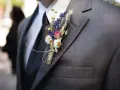 Elegancka butonierka co to? Bukiecik z suszonych kwiatów przyczepiony do marynarki.
