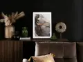 Elegancka komoda z ryflowanymi frontami w brązowym kolorze ścian. Na blacie wazony, grafika i ozdoby.