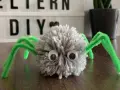 Süße Spinnen-Deko aus Wolle und Pfeifenreinigern, perfekt zum Spinnennetz basteln mit Kindern.