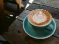 Aromaticzna kawa ristretto z pianką latte art na drewnianym blacie. Idealny poranek.