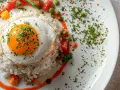 Arroz a la cubana con huevo frito, tomate, guisantes y salsa.