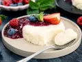 Cremige bayrische Creme mit Beerensoße, Erdbeere und Minze. Ein Löffel voller Genuss.