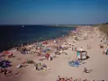 Tłum plażowiczów na piaszczystej plaży, woda i niebo. Czy to Darłówko wschodnie czy zachodnie?