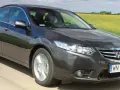 Ciemnoszary sedan Honda Accord, idealny auto do 40 tys., jedzie przez pola rzepaku.