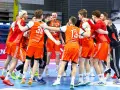 Drużyna Zagłębia Lubin piłka ręczna mężczyzn świętuje zwycięstwo. Zawodnicy w pomarańczowych strojach przytulają się, tworząc radosny krąg.