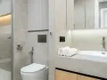 Modernt kaklat badrum med dusch, toalett och handfat. Ljus och stilren design.