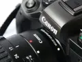 Zbliżenie na czarną lustrzankę Canon z obiektywem.