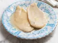 Delicate scaloppine al vino bianco, servite su un piatto decorato con motivi blu.