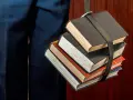 Un fascio di libri legati da una cinghia, un simbolo del percorso per capire come funzionano i CFU e il carico di studio.