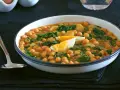 Plato humeante de garbanzos con espinacas y huevo duro, una deliciosa receta de garbanzos tradicional.