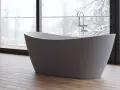Une baignoire moderne dans une chambre, avec une grande fenêtre offrant une vue sur un paysage enneigé. Parfait pour un moment de détente.