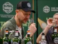Mann mit Kappe riecht an einem Whiskyglas bei einer Whisky Messe. Flaschen stehen auf dem Tisch.