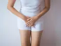 Kobieta w białej bieliźnie, dłonie zasłaniające krocze. Może symbolizować żółte upławy w okresie menopauzy.