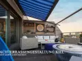 Gemütliche Dachterrasse mit Lounge-Möbeln, blauem Sonnensegel und Blick auf die Stadt.