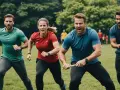 Quatre personnes en tenue de sport courent sur l'herbe, déterminées. Un défi sportif d'entreprise en plein air.