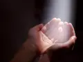 Hände im Licht, die Hoffnung suchen. Ein Symbol für gott und das Leid, das durch Glauben überwunden werden kann.