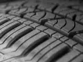 Primo piano del battistrada di un pneumatico, con le scanalature che garantiscono aderenza e stabilità per una guida sicura ad alta velocita.
