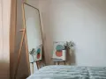 Lustro odbija plakat z kołami i wazon z suszonymi kwiatami. To inspiracja do stworzenia własnej konmari listy porządków.