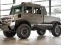Szary, potężny Unimog U 4030 z podwójną kabiną i terenowymi oponami gotowy na każdą przygodę.