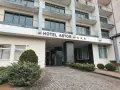 Hotel Astor Jastrzębia Góra – opinie o obiekcie z trzema gwiazdkami. Wejście do hotelu z podjazdem i zielenią.